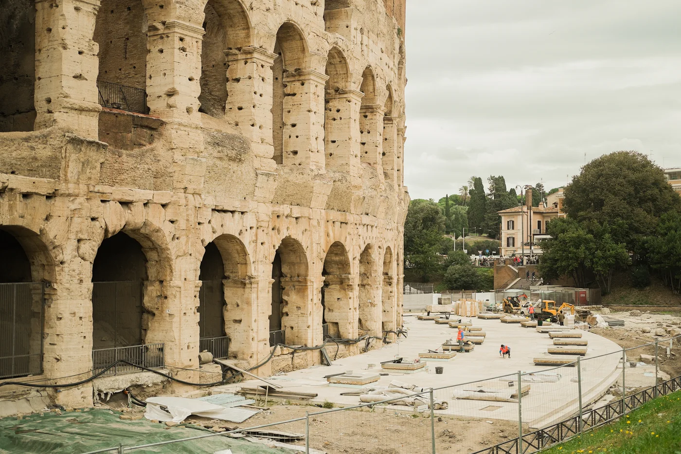 Wide view of the restoration site along the Colosseum’s ambulacri, workers and new stone slabs in place